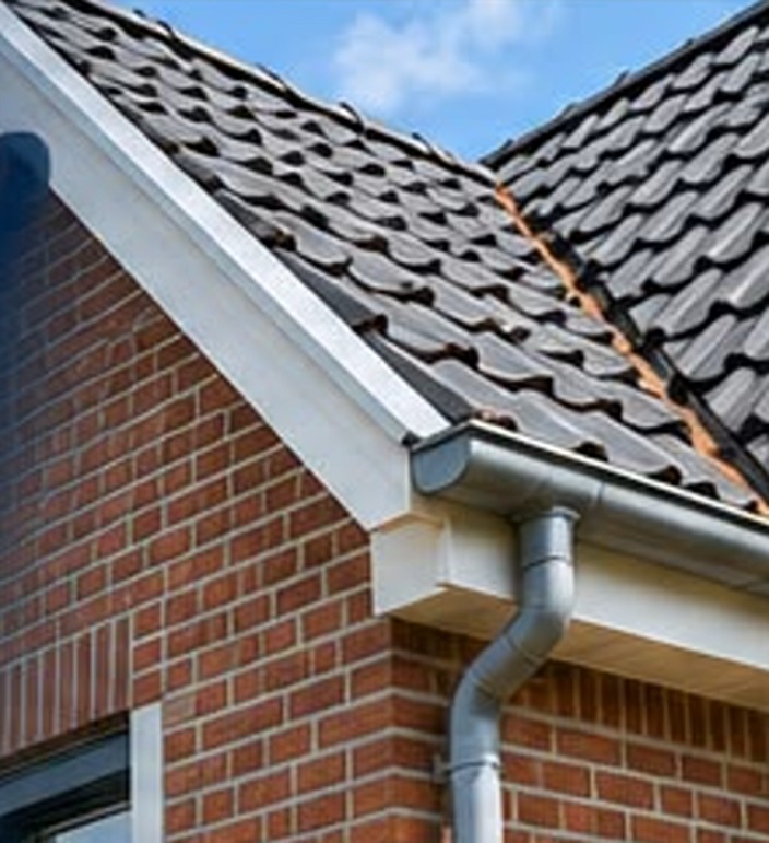 Detail van dakgoot, regenpijp en gevel